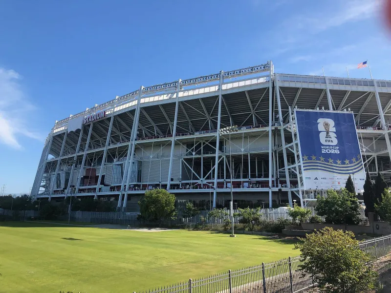 Levi’s Stadium, temporarily rebranded as San Francisco Bay Area Stadium for the 2026 FIFA World Cup, as seen from the east along Tasman Drive in front of the Santa Clara Youth Soccer Park. “FIFA World Cup 2026” billboards rise above Toyota Gate F. The Levi’s logo in the stadium sign is covered in a 